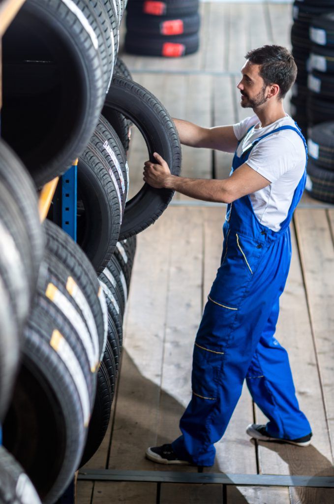 Mechanic picking out a tyre from stock - Order Tyres Online in Norwich with Tyres-2-U